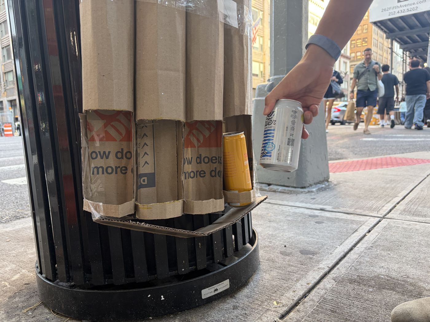 A hand taking a can out of the window at the bottom of the tube